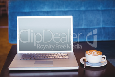 Close-up of laptop and coffee on table