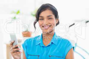 Casual businesswoman text messaging in office