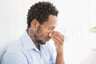 Young concentrating business man leaning against a wall