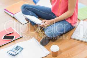 Young creative businesswoman scrolling on tablet