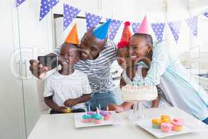 Happy family celebrating a birthday together and taking a selfie