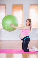Pregnant woman holding exercise ball