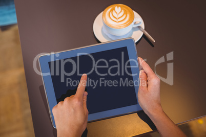 Close-up of digital tablet and coffee on table