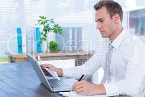 Attentive businessman writing on notebook