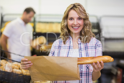 Portrait of a smiling blonde woman taking a bread