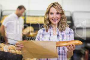 Portrait of a smiling blonde woman taking a bread