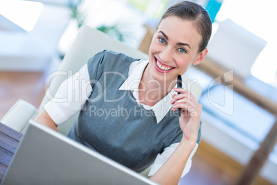 Happy businesswoman working on laptop computer