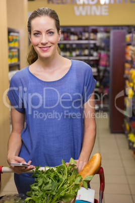 Thoughtful pretty woman pushing trolley