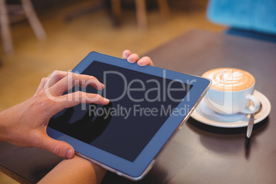 Close-up of digital tablet and coffee on table