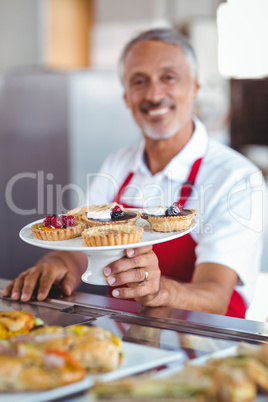 Barista holding a plate of pastries