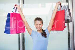 Young happy woman holding up her shopping bags