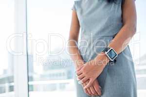 Businesswoman wearing a smartwatch with arms folded