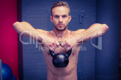 Muscular man lifting a kettlebell