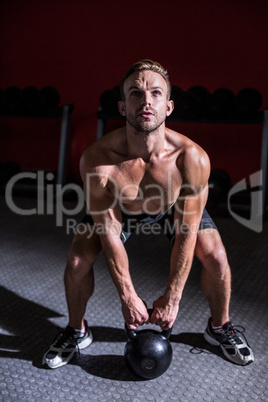 Muscular man lifting a kettlebell