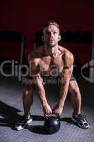 Muscular man lifting a kettlebell