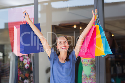 Energetic woman handing shopping bags