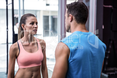 Young worried bodybuilder talking to her colleague