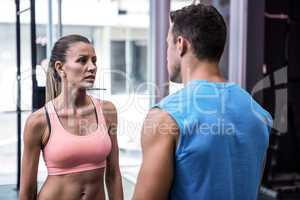 Young worried bodybuilder talking to her colleague