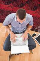 Young creative businessman typing on laptop