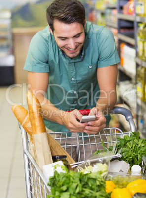 Smiling man buy products and using his smaprtphone