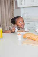 Smiling beautiful little girl eating cereals