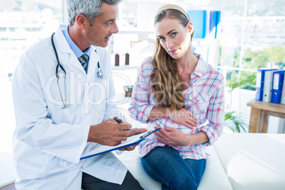 Sitting pregnant woman talking to her doctor