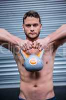 Portrait of muscular man lifting a kettlebell