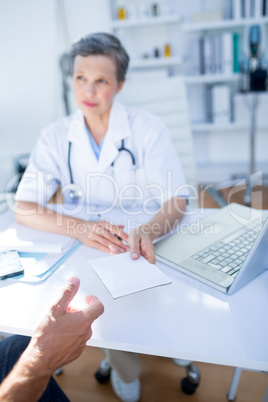 Female doctor giving prescription to her patient