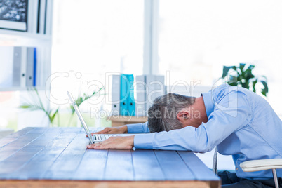 Businessman lying on his desk