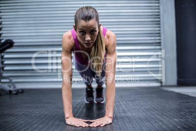 Muscular woman doing press up exercises