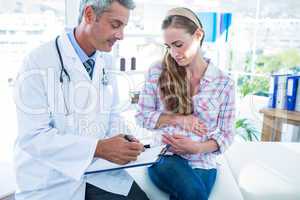 Sitting pregnant woman talking to her doctor