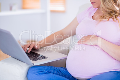 Pregnant woman using her laptop