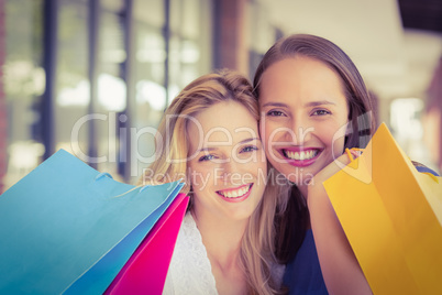 Happy friends holding shopping bags