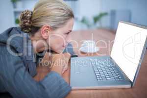 Attentive blonde businesswoman watching her laptop