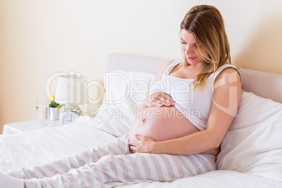 Pregnant woman looking at her belly