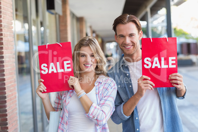 A happy couple with "SALE" shopping bags