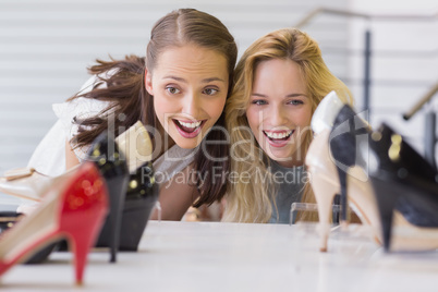 Two excited women looking at heel shoes