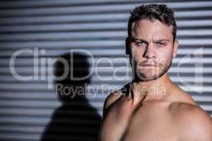 Portrait of serious muscular man looking at camera