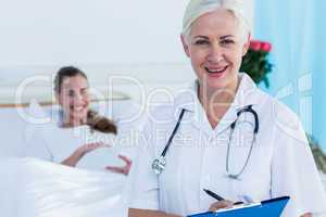 Female doctor and pregnant woman smiling at camera