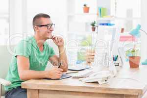 Young creative businessman drawing on graphic tablet