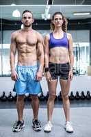 A standing muscular couple posing