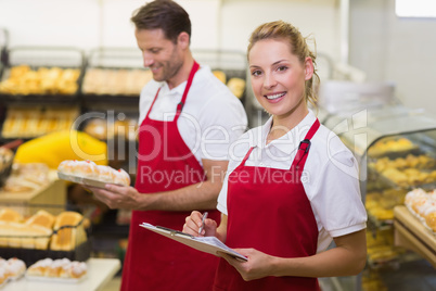 Portrait of a smiling baker with her colleague