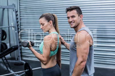 A muscular woman lifting dumbbells