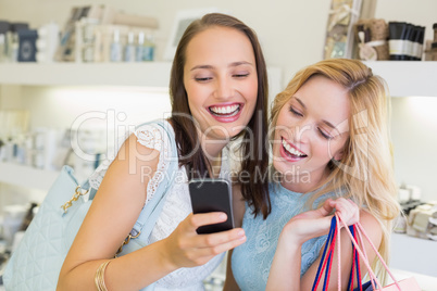Happy friends women looking at smartphone
