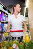 Portrait of smiling woman walking in aisle with his trollet