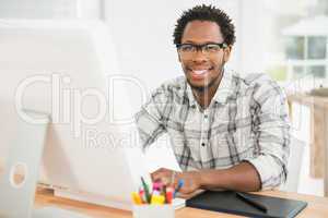 Portrait of smiling casual businessman working with computer and