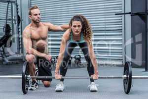 Attentive muscular woman lifting weight