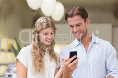 A happy couple looking at smartphone