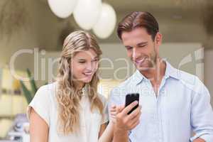 A happy couple looking at smartphone