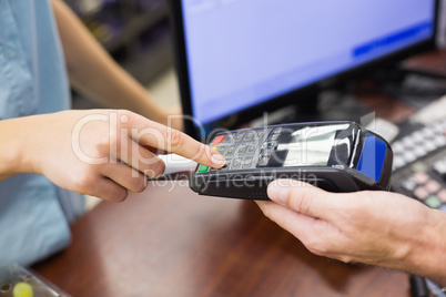 Woman at cash register paying with credit card